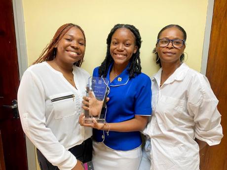Thalia Grant (centre) posing with mom Sherine Bucknor (right) and Thalia’s best friend Cam-Ron Davis after collecting the award for being top regional performer in the Caribbean Advanced Proficiency Examination business studies for 2022. 
