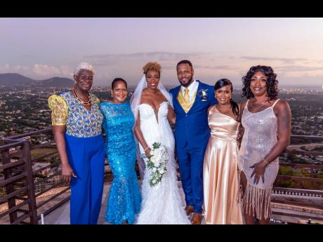 From left: Edna Robinson, mother of the bride; Maxine Allen, mother of the groom; the newly-weds; Sasha Marsh, sister of the groom and a bridesmaid; and Talia Tyrrell, sister of the bride, smile into the sunset.