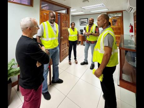 KFTL CEO Capt Jedrzej Mierzewski (left), along with members of the Human Resources and Industrial Relations team, share encouraging words with Anthony Davis (second left) and Kaneil McKenzie (right) ahead of their departure to Nigeria.