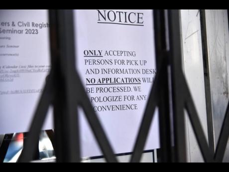 A sign posted at the 58 Duke Street offices of the Registrar General’s Department advising of a scaling down of operations.