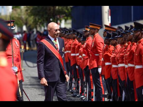 Governor General Sir Patrick Allen inspects the guard of honour by members of the Jamaica Defence Force during the ceremonial opening of Parliament on Duke Street Tuesday. 
