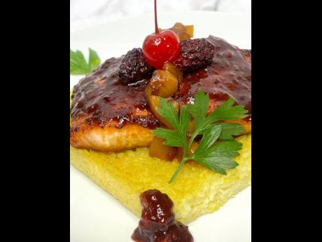 The wild berry salmon is presented on a bed of sticky rice.