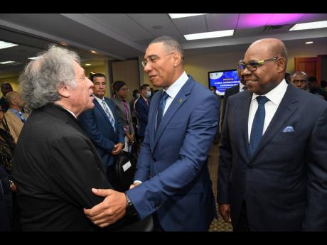 Tourism Minister Edmund Bartlett (right) watches as Prime Minister Andrew Holness (centre) greets Luis Almagro, secretary general of the Organization of American States, during the opening ceremony of the Global Tourism Resilience Conference at the Regiona