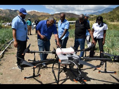Stephen Jones (second left), chief strategic officer of environment solutions at the Rural Agricultural Development Authority (RADA), discusses how the agricultural drone works with (from left) Hartnell Campbell, senior programmer, RADA; Agriculture Minist