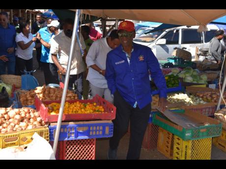 Demond McKenzie (foreground), minister of Local Government and Rural Development, tours the  Charles Gordon Market in Montego Bay, St James, on Wednesday.