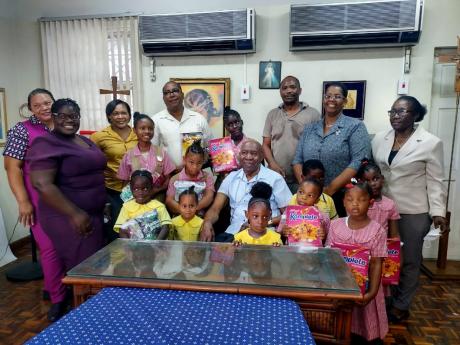 Rev. Burchell McPherson (centre, second row), Bishop of Montego Bay, with principals and students from  St Mary’s Roman Catholic Early Childhood, Cambridge Infant School, and Chetwood Memorial Primary School, after collecting their snack packs on Monday,