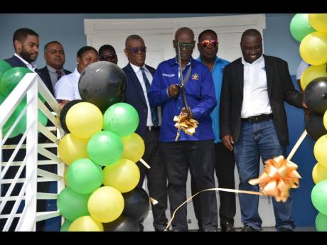 Desmond McKenzie (centre), minister of local government and rural development, cuts the ribbon to open the new male ward at the St James Infirmary on February 15. With him are (from left) David Brown, councillor of the Montego Bay West Division; Bryce Gran