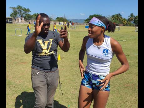 Mount Alvernia Coach Andrew Henry demonstrates ideal technique for his Class  One long jumper Aaliyah Foster at Western Champs.