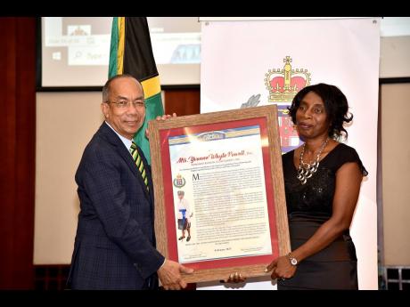 The Most Outstanding Police Officer in St James, retired Deputy Superintendent Yvonne Powell, accepts a citation from Minister of National Security Dr Horace Chang.