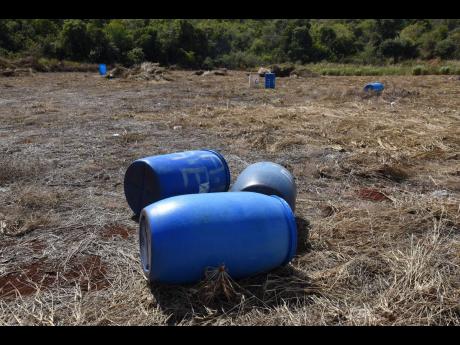 Empty drums lie scattered in a field in Flagaman, St Elizabeth, last Wednesday. The area has been experiencing drought conditions since the latter part of 2022 with some farmers opting not to start cultivating their farms until there is a reliable source o