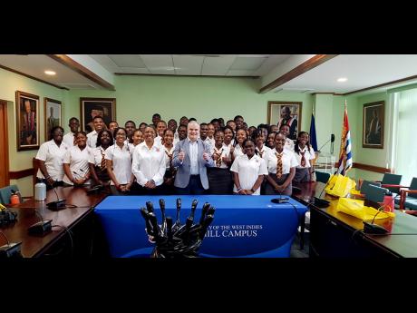 Professor Clive Landis (centre), principal of The University of the West Indies, Cave Hill campus and Grace Baston, principal of Campion College with Campion College and Harrison College students.