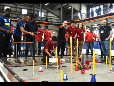 Members of the Munro College team and the Carol Morgan School’s CMS Sharks team go head-to-head in a match during the NCB Foundation FIRST Tech Challenge Jamaica National Robotics Championship at the Karl Hendrickson Auditorium at Jamaica College in St A