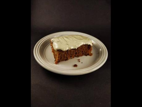 A slice of Cuh Crumbs’ famous carrot cake served with cream cheese frosting.