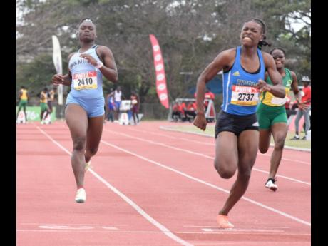 Hydel High School’s Alana Reid (right) wins the Girls’ Class One 100 metres at ahead of Edwin Allen’s Serena Cole on day one of Central Athletics Championships at the G.C. Foster College yesterday. 