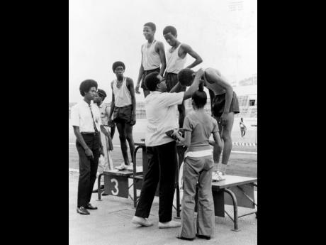 1973: Members of the victorious Calabar class III 4×100 metres relay team receiving their medals from the Rev. Gervaise Clarke during the Gibson Relays at the National Stadium on March 3.