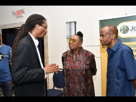 JAMMS  General Manager, Evon Mullings (left), engaging Minister Grange and Kendall Minister, entertainment attorney and one of the international presenters at the seminar at The Jamaica Pegasus Hhotel in New Kingston.