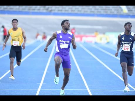 Kingston College’s (KC) Bouwahjgie Nkrumie (centre) checks his time after winning the Class I boys’ 100 metres at the Anthrick Corporate Area Athletics Championships at the National Stadium today. Nkrumie clocked 10.32 seconds to win ahead of Jamaica C