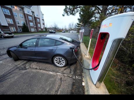 A Tesla sedan gets a charge at a Tesla Supercharging station. 