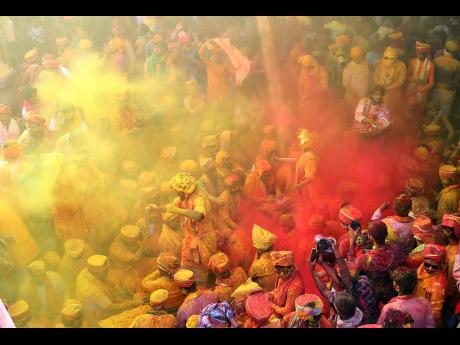 People play with colours as they take part in the Holi festival celebrations, at Sriji temple, Barsana, Mathura, India.