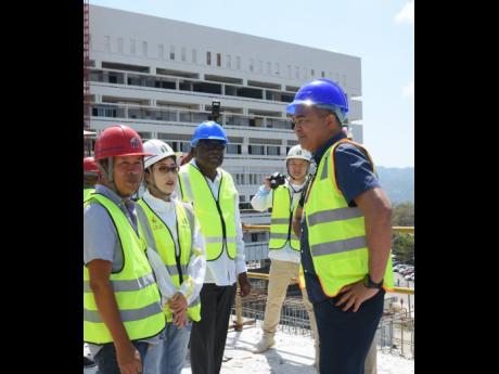 On Friday, Health Minister Dr Christopher Tufton (right) toured the Cornwall Regional Hospital in St James, discussing the ongoing restoration project with (left) Qiu Ye Bo, Fiona Wang and Conrad Pitkin, Custos of St James.