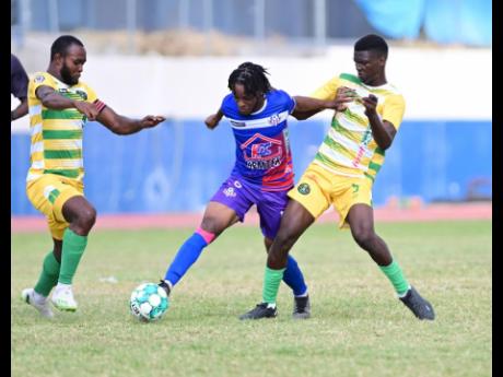 Portmore United’s Alex Marshall (centre) powers past Fitzroy Cummings (left) and Derwayne Dyer of Vere United during a Jamaica Premier League match at  Ashenheim Stadium, Jamaica College on Sunday, February 26, 2023. Coach Phillip Williams says Marshall 