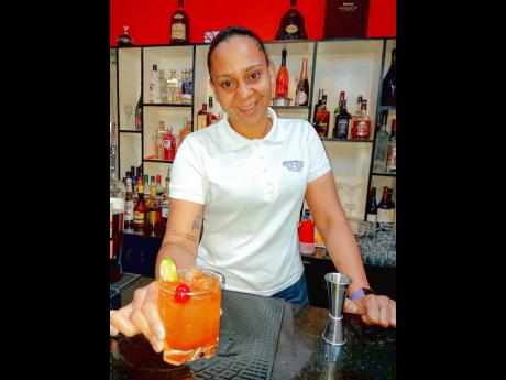 Ewart presents one of her signature mixes, the Red Rume Crush, with a smile.