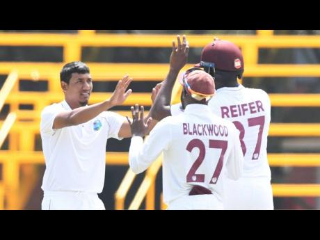 West Indies spinner Gudakesh Motie (left) celebrates a South African wicket with teammates Jermaine Blackwood (centre) and Raymon Reifer during day one of the teams’ second Test at the Wanderers in Johannesburg, South Africa, yesterday.