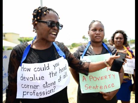 From left: Taneka Mckoy-Phipps, Shereece Bryan and Susan Campbell take part in a protest in the vicinity of the Ministry of Finance and the Public Service in Kingston on Wednesday as public sector teachers continued to register their disappointment with th
