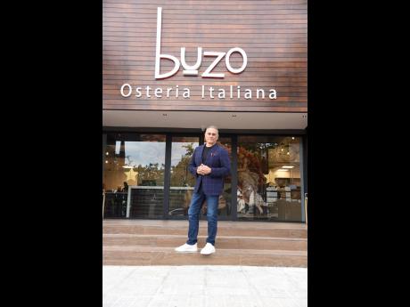 Peter George, CEO of Trotters Restaurant Group at the entrance of the Buzo Osteria Italiana location in New Kingston.