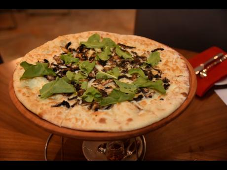 The Buzo Pizza with wild mushroom, arugula, truffle oil, and pepper flakes. 
