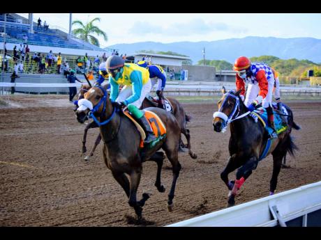 TEKAPUNT (left), ridden by Phillip Parchment, wins last year’s  Sir Howard Stakes ahead of SHADOWFAX at Caymanas Park on  Sunday, March 13, 2022.