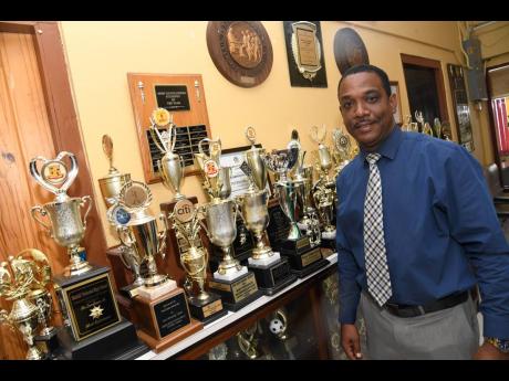Anthony Garwood, principal at Dinthill Technical High School, shows some of the awards the school has gained in academics and sports. 