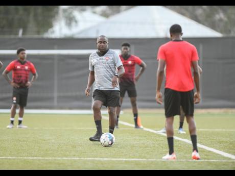Trinidad and Tobago’s head coach Angus Eve (centre) at a training session with his players  at the UWI/JFF Captain Horace Burrell Centre of Excellence on Thursday.