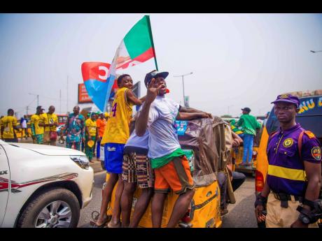 
Supporters of Bola Ahmed Tinubu, the presidential candidate of the All Progressives Congress, Nigeria ruling party, rides on an autorickshaw outside the venue of an election campaign rally at the Teslim Balogun Stadium in Lagos.