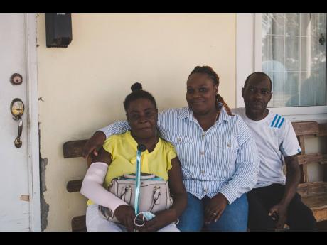 Trudy-Ann Dixon-Smith, daughter of Robert ‘Bobby Digital’ Dixon, sits  between the two beneficiaries of assistance provided by the Digital B Foundation launched on World Kidney Day. 