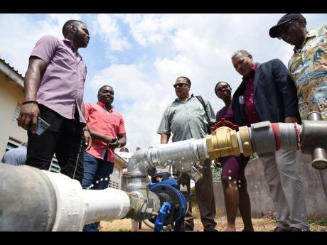 From left: Stephen Jones, senior technical officer, Konnexx, and Charles Reid, solar manager, Konnexx, explain how the pump works to water the Boys’ Town playing fields to Raymond Connell, past president, University District Rotary Club of Seattle; Nicol
