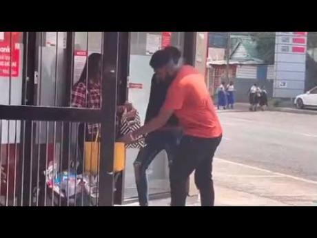 Pranksters harassing a woman outside an ATM in Half-Way Tree, St Andrew.