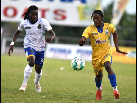 Vere United FC’s Steve Pinnock (left) tries to keep pace with Molynes United’s Shamario Dennis during their Jamaica Premier League encounter at the Anthony Spaulding Sports Complex last evening. 