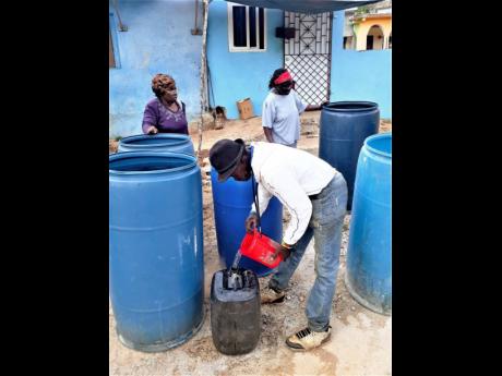 Residents of Nine Miles in St Ann share water supplied by Discovery Bauxite to communities and individuals to help to alleviate the severe drought conditions being experienced.