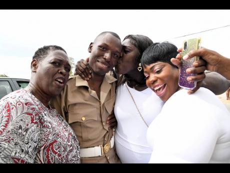 Graduate of the Jamaica National Service Corps (JNSC) intake 2022/01, Rojanie Bedasee (second left), is embraced by members of his family (from left), Margaret Bloomfield, grandmother; Maxine Watson, grandmother and his mother Soshanna Ennis. The JNSC grad