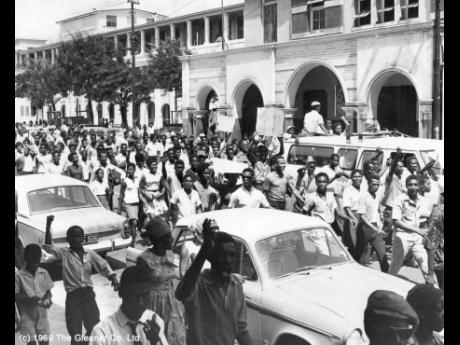 In this 1968 photo Walter Rodney demonstrators march down King Street in the vicinity of the Supreme Court buildings heading for Harbour Street where they held a meeting in front of The Gleaner building.