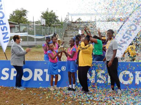 
St Patrick’s Primary School players celebrate with the winners’ trophy after claiming the Insports Primary Schools’ netball title at the Discovery Bay Community Centre on Friday. Looking on, from left, are: Member of Parliament Krystal Lee, Sports M