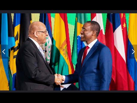 Jamaica’s Finance Minister Dr Nigel Clarke (right), the outgoing chairman of the Board of Governors of the Inter-American Development Bank, greets incoming chairman and Panama’s Finance Minister, Hector Alexander, at the institution’s 2023 Annual Mee