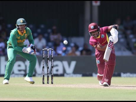 
West Indies captain Shai Hope (right) drives through the offside while South African wicketkeeper Quinton de Kock looks on during the team’s second One-Day International in East London, South Africa yesterday.  