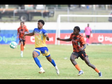 Diego McKenzie (right) of Tivoli Gardens tackles Romaine Brackenridge of Harbour View FC during the Jamaica Premier League match at the Ashenheim Stadium, Jamaica College yesterday. The game ended in a 2-2 draw.