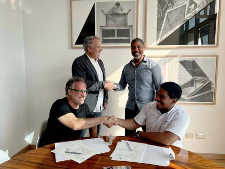 Seated: Jose Antonio Mesones (left), creative director at  Partn&rs Ltd, and Craig Powe, CEO of Adtelligent Ltd, shake hands to seal their partnership agreement.  Standing: Alejandro Agois (left), commercial director at Partn&rs Ltd, and Sheldon Powe, CEO 