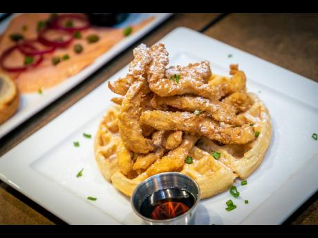 Below:
Waffles and crispy chicken tenders, served with a side of maple syrup and topped with a dash of powdered sugar.