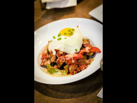 Fridays breakfast hash includes potatoes layered with thinly sliced sirloin steak, green onions, pepper onion medley, Monterey Jack cheese and marinara sauce. It is topped with a sunny-side-up egg.