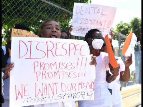 Dental assistants protesting outside the Ministry of Finance and the Public Service’s Heroes Circle offices in Kingston on Wednesday as a delay in payment of new salary scales caused jitters.