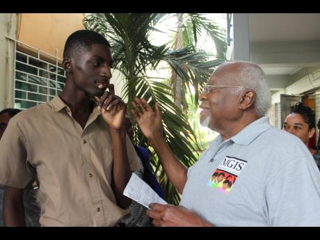 Oneil Clarke, grade-10 student at Marcus Garvey Technical High School in St Ann’s Bay, listens as Dr Julius Garvey, younger son of National Hero Marcus Garvey, makes a point at a recent Black History Month event at The Mico University College in Kingston